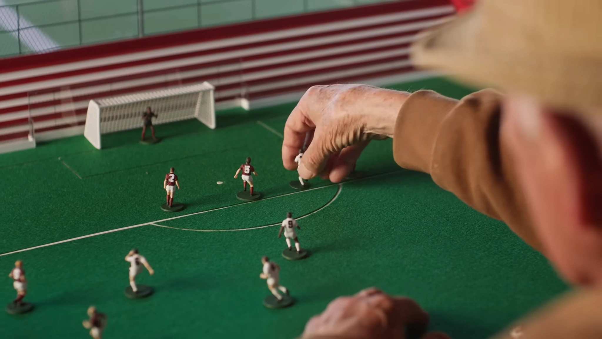 Maquete de um campo de futebol, com jogadores em miniatura.
