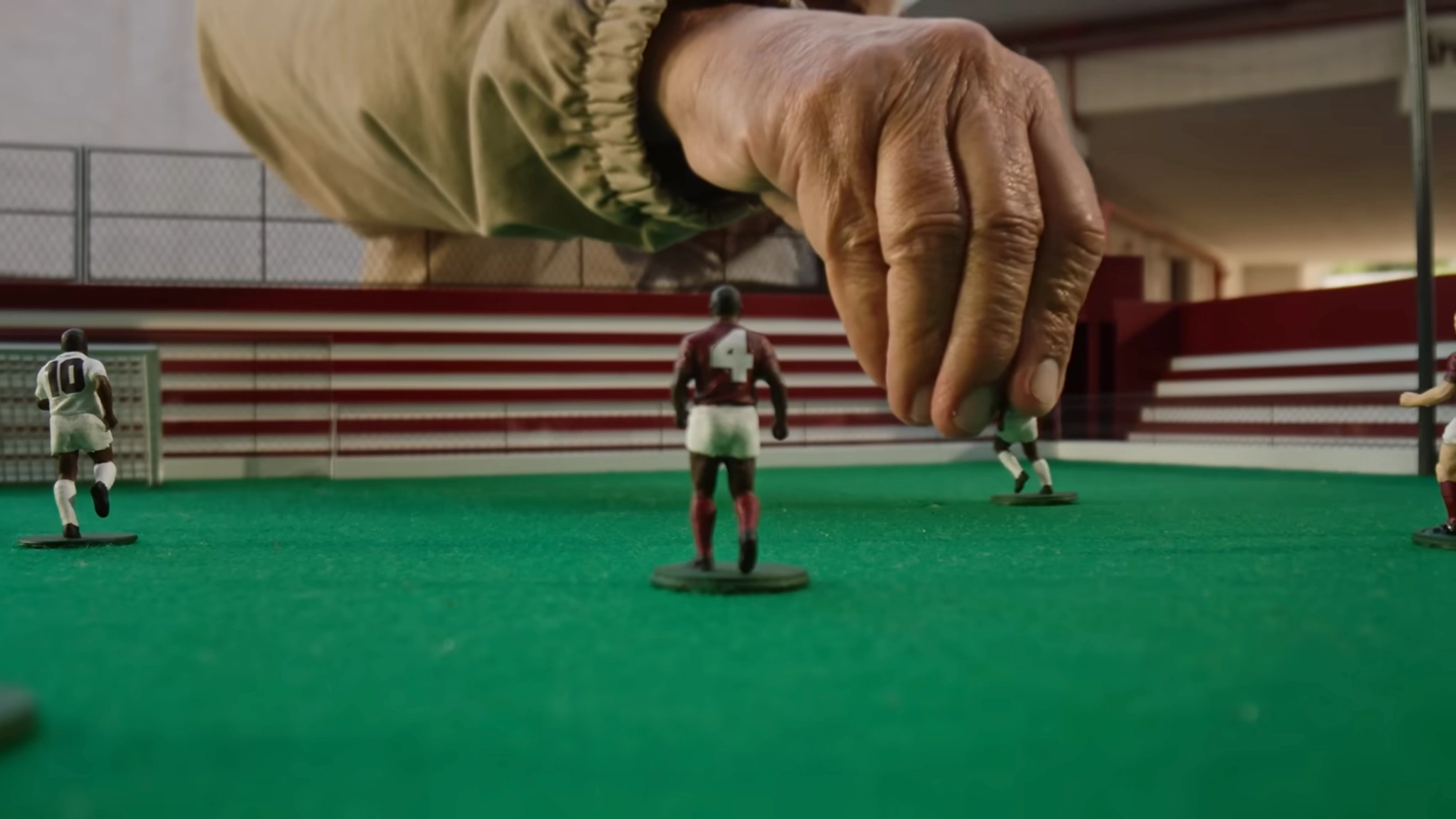 Detalhe de uma mão posicionando um jogador na maquete.