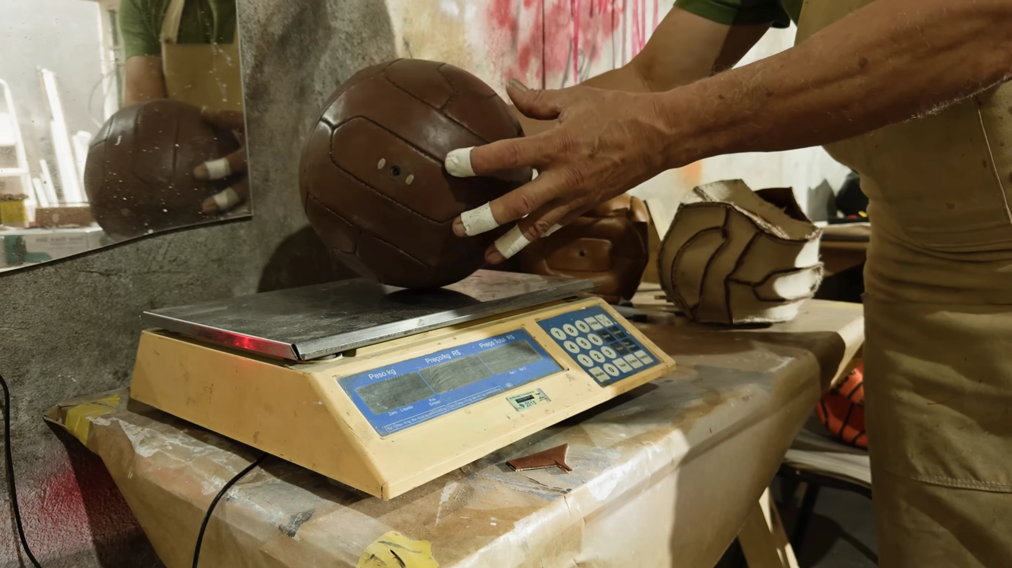 Bola de couro sendo pesada em uma balança.