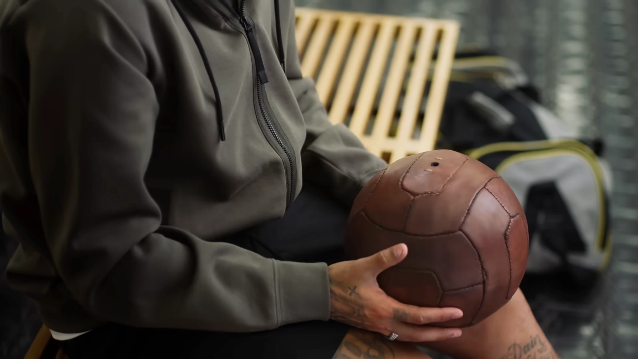 Detalhe das mãos segurando a bola de couro.